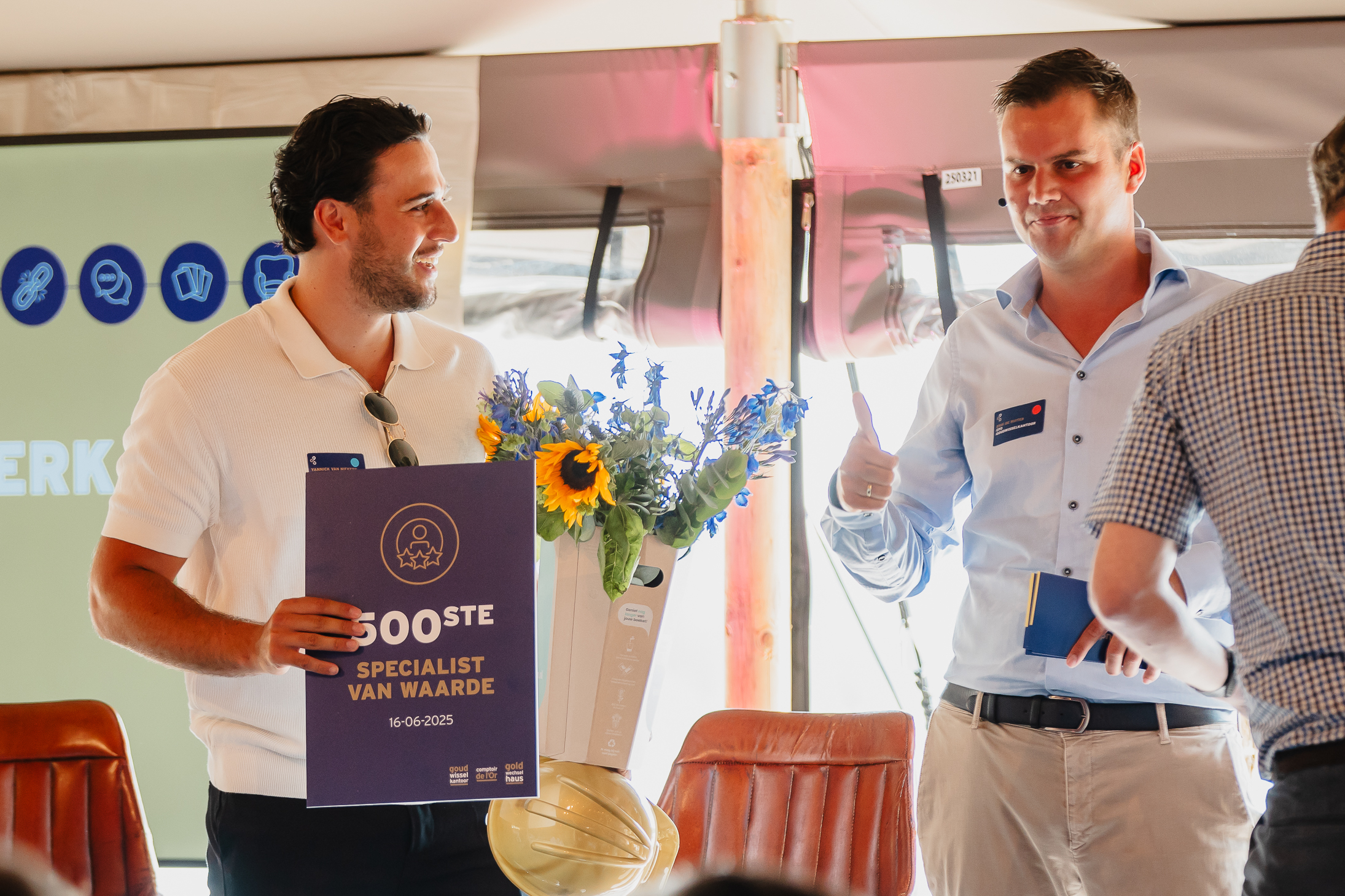 De vijfhonderdste Goudwisselkantoor medewerker wordt gefeliciteerd door CFO Erik de Ruiter.
